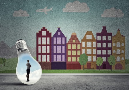 Businesswoman inside light bulb against city drawn conceptの写真素材