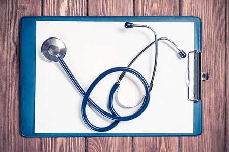 Doctors wooden table with tablet stethoscope and other stuffの写真素材
