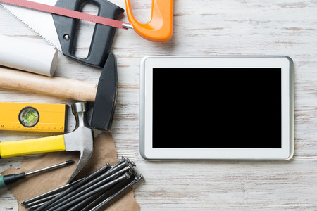 Set of industrial tools and tablet on wooden surfaceの写真素材