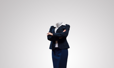 Headless businesswoman with arms crossed on chest on gray backgroundの写真素材
