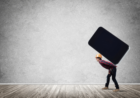 Man engineer carrying on back big smartphoneの写真素材