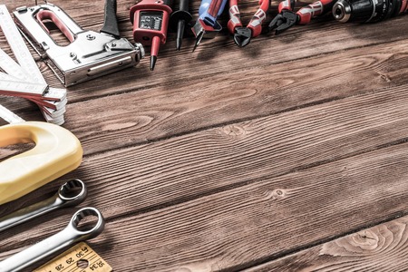 Variety of repair tools on wooden surface and place for text