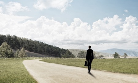 Elegant businesswoman on road standing with back and looking aheadの写真素材