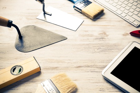 Set of industrial tools and tablet on wooden surface
