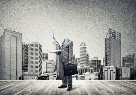 Headless engineer man with papers in hand against construction backgroundの写真素材