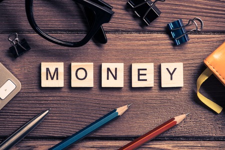Workspace desk with keyboard office working stuff and wooden elements with the letters collected in the word moneyの写真素材