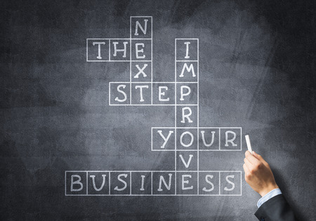 Business concept with crossword drawn with chalk on blackboardの写真素材
