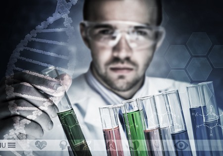 Young scientist mixing reagents in glass flask in clinical laboratoryの写真素材