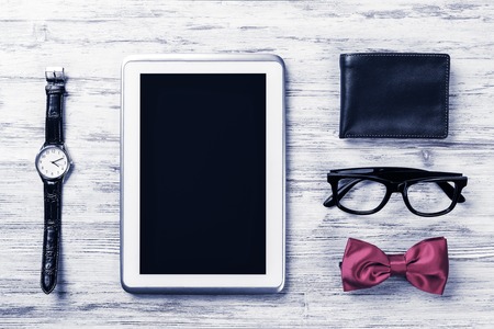 Gentleman kit of tablet watch glasses bow tie and notebook on woの写真素材