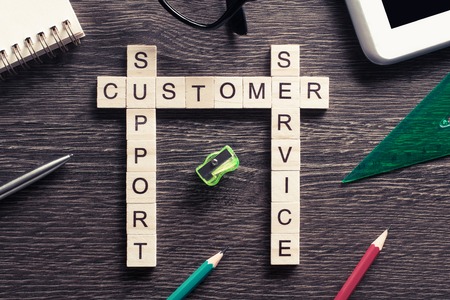 Business workplace with office stuff and wooden cubes making crosswordの写真素材