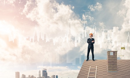 Engineer man standing on roof and looking away. Mixed mediaの写真素材