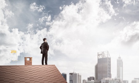 Mister boss on brick roof with arms akimbo. Mixed mediaの写真素材