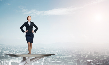 Confident elegant businesswoman presented on metal tray against cityscape backgroundの写真素材