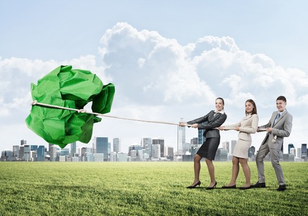Young business people outdoors and huge paper ball as symbol of creativityの写真素材