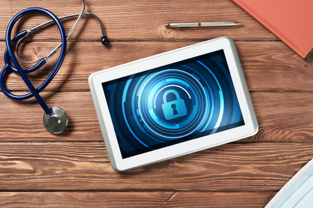 Web security and technology concept with tablet pc on wooden tableの写真素材