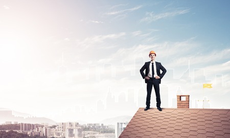 Engineer man standing on roof and looking away. Mixed mediaの写真素材