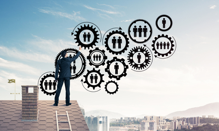 Businessman on house roof presenting teamwork and connection conの写真素材