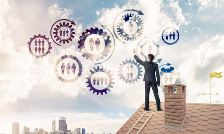 Businessman on house roof presenting teamwork and connection conceptの写真素材