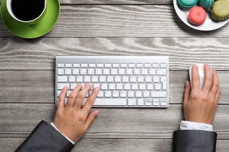 Top view of businesswoman hands using keyboard and mouseの写真素材
