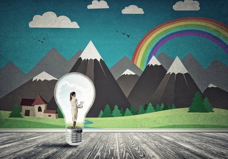 Businesswoman inside light bulb in room against nature drawn conceptの写真素材