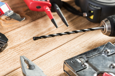 Drill pliers screwdriver tools on wooden table