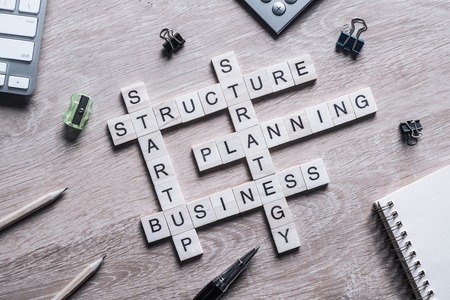 Words of business concepts collected in crossword with wooden cubesの写真素材