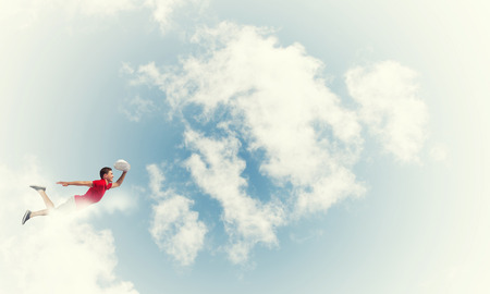 Young cheerful man flying high in skyの写真素材