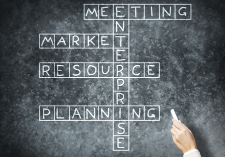 Business concept with crossword drawn with chalk on blackboardの写真素材