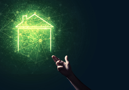 Hand of man touching with finger glowing home icon or symbolの写真素材