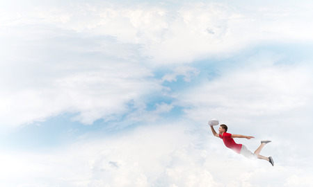 Young cheerful man flying high in skyの写真素材