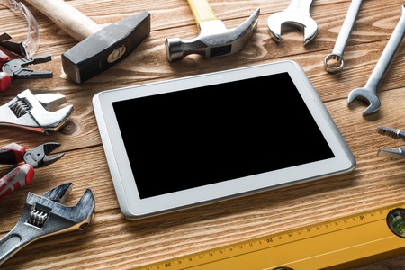 Variety of tools of builder and tablet pc on wooden texture table