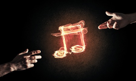 Close up of person hand and fire music symbol on dark backgroundの写真素材