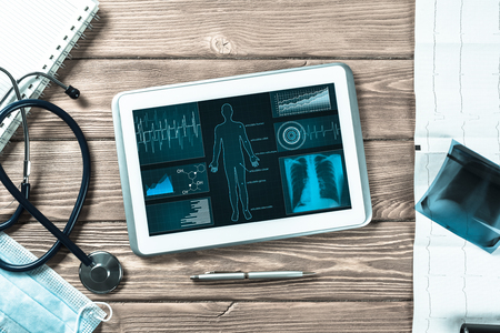 White tablet pc and doctor tools on wooden tableの写真素材