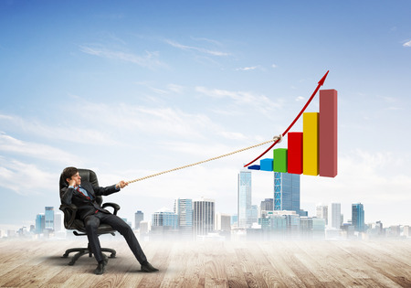 Young businessman outdoors making huge graph moveの写真素材