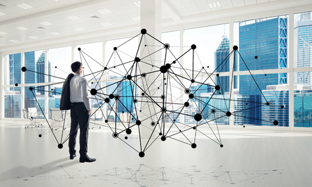 Elegant businessman in modern office interior and social connection concept. Mixed mediaの写真素材