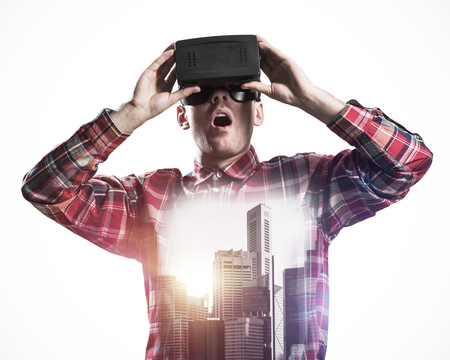 Young man with virtual reality headset or 3d glasses over cityscape background
