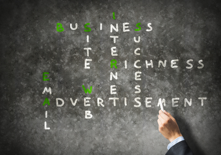 Business concept with crossword drawn with chalk on blackboardの写真素材