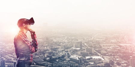 Young man with virtual reality headset or 3d glasses over cityscape background