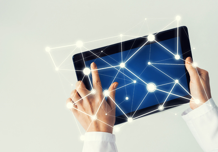 Tablet pc device with connection lines on screen in hands of doctorの写真素材