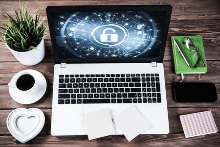 Business workplace with office stuff and laptop with padlock icons on screenの写真素材
