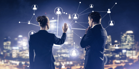 Businessman and businesswoman standing with back and touching connection conceptの写真素材