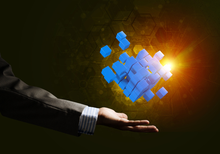Close of businessman hand holding cube figure as symbol of innovation. 3D renderingの写真素材