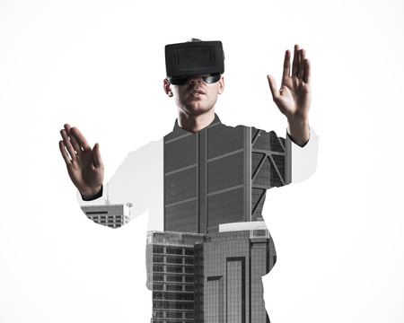 Young man with virtual reality headset or 3d glasses over cityscape backgroundの写真素材