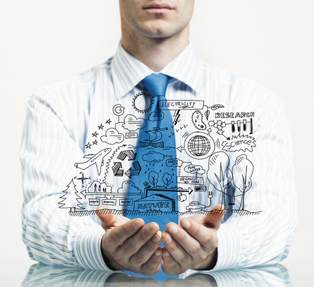 Businessman at table presenting business sketched plan in palmの写真素材