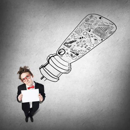 Top view of funny businessman holding blank paper sheetの写真素材