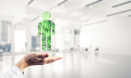 Close of male hands holding person gear figure in palmの写真素材