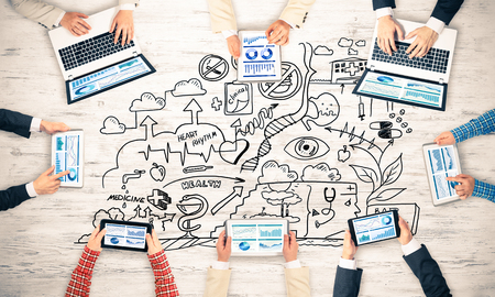 Group of people with devices in hands working together as symbol of networking and communicationの写真素材