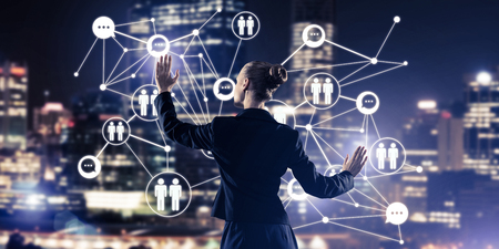 Back view of businesswoman against night cityscape working with social connection media conceptの写真素材