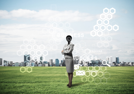 Elegant businesswoman outdoors with camera instead of head and media interface on screenの写真素材