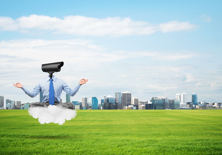 Elegant businessman outdoors floating on cloud and camera instead of headの写真素材
